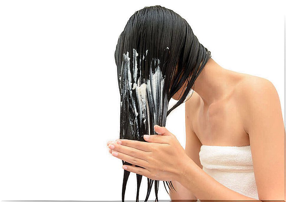 Woman applying a mask to her hair.