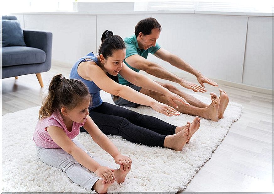 Family reaching out to touch their toes.