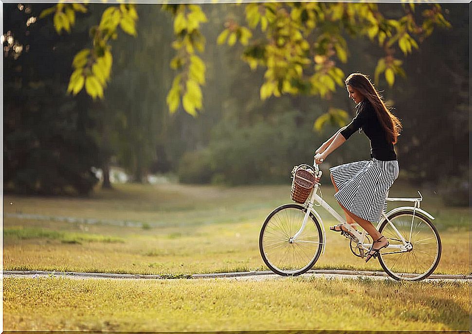 Woman cycling to increase physical activity.