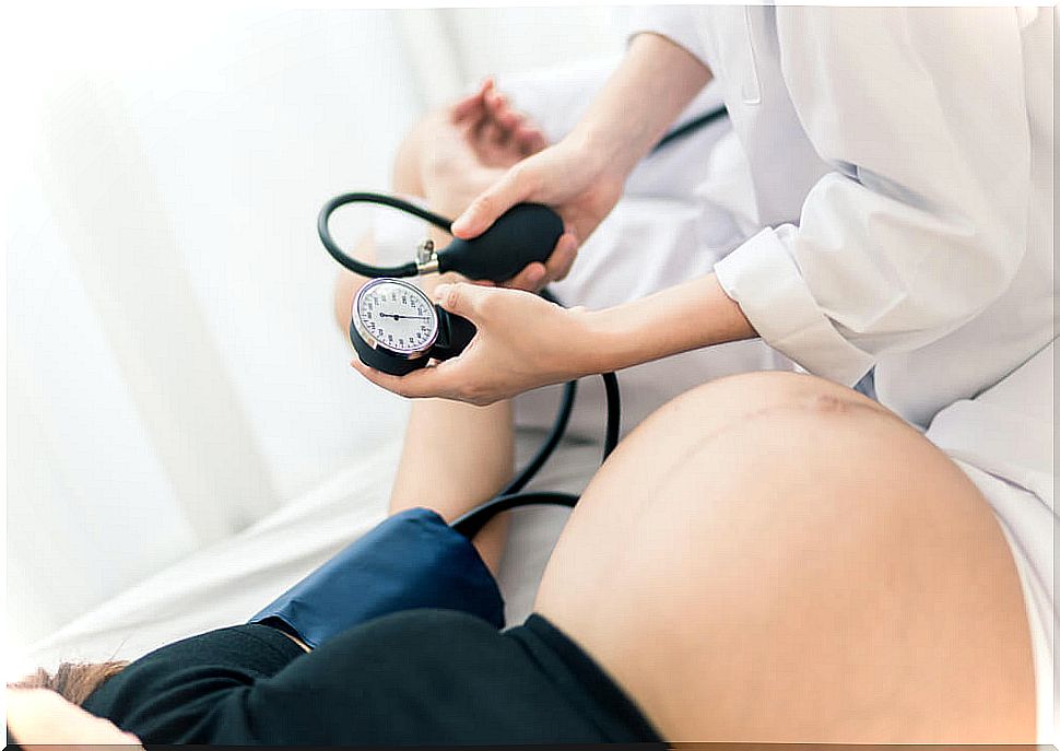 Pregnant woman measuring her blood pressure