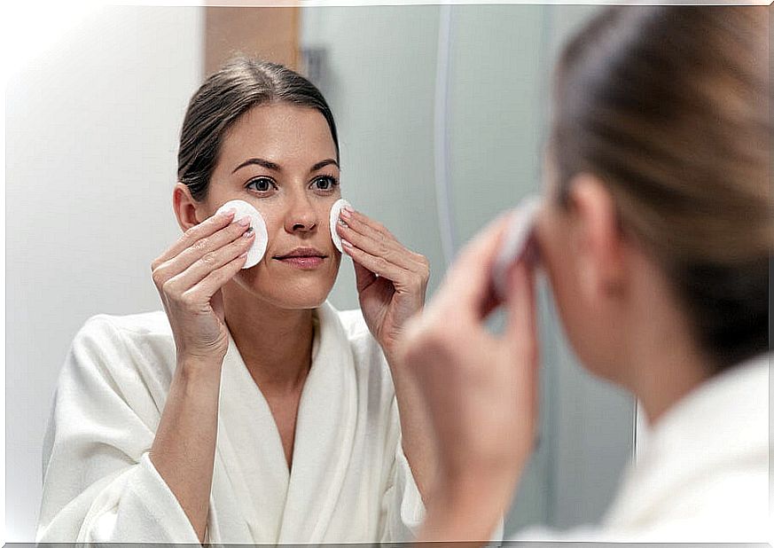 Woman cleaning her face to have radiant skin