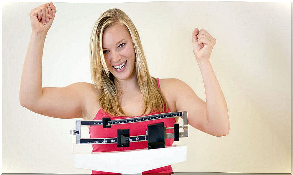 Happy woman on a weight scale.