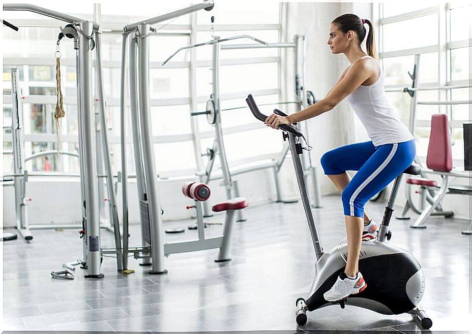 Woman doing exercise bike in gym.